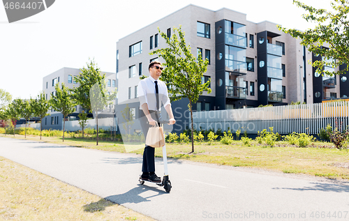 Image of businessman with takeaway lunch riding scooter