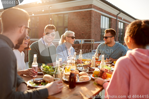 Image of friends having dinner or bbq party on rooftop