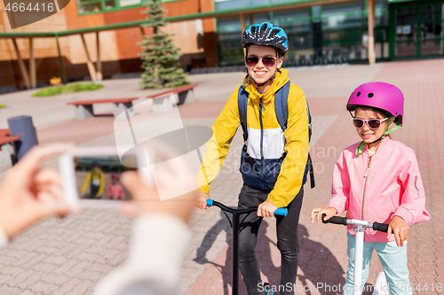 Image of school kids with scooters photographing by cell