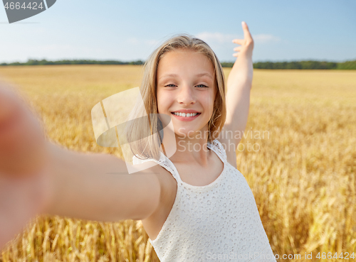 Image of happy girl taking selfie on cereal field