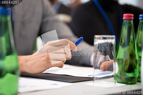 Image of hands of businessman at business conference