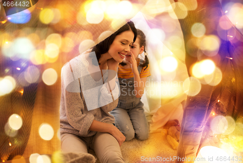 Image of happy family whispering in kids tent at home