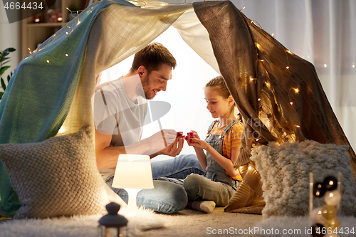 Image of family playing tea party in kids tent at home