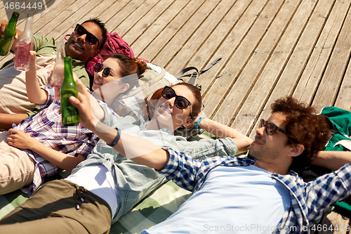 Image of friends drinking beer and cider on wooden terrace