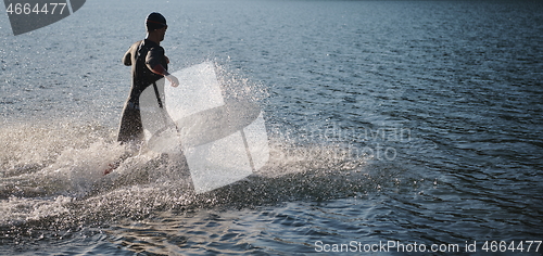 Image of triathlon athlete starting swimming training on lake