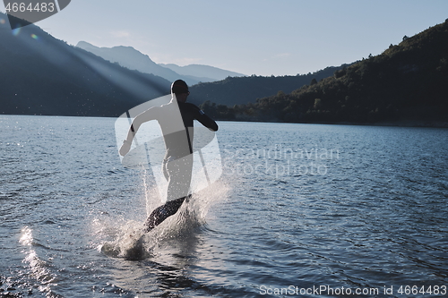 Image of triathlon athlete starting swimming training on lake