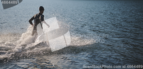 Image of triathlon athlete starting swimming training on lake