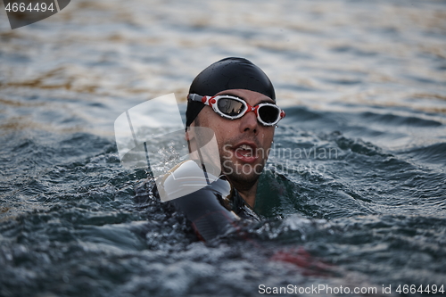 Image of triathlete swimmer having a break during hard training