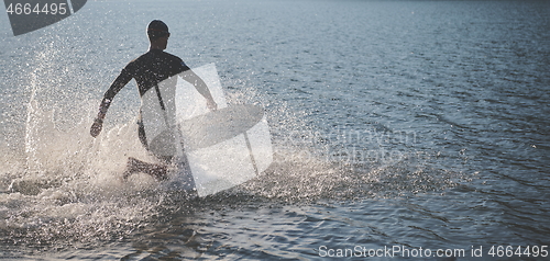 Image of triathlon athlete starting swimming training on lake