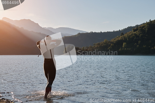 Image of triathlon athlete starting swimming training on lake