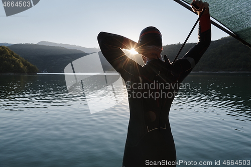 Image of triathlon athlete starting swimming training on lake