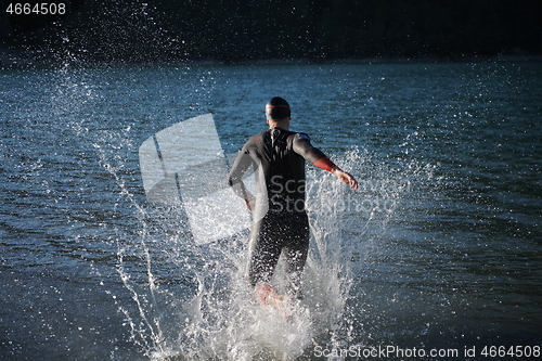 Image of triathlon athlete starting swimming training on lake