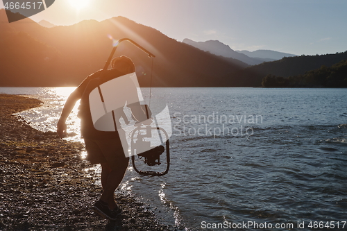 Image of videographer taking action shot of triathlon swimming athlete