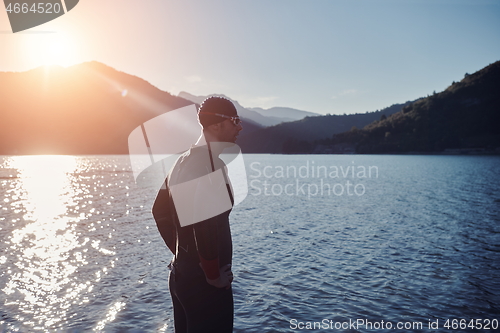 Image of triathlon athlete starting swimming training on lake