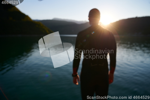 Image of triathlon athlete starting swimming training on lake