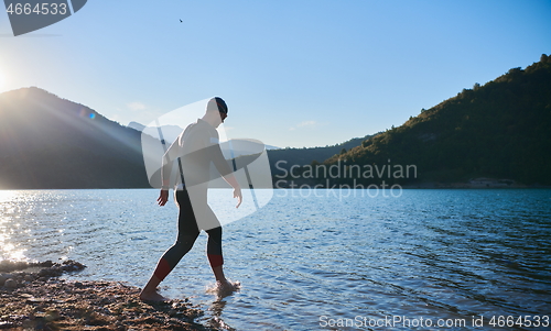 Image of triathlon athlete starting swimming training on lake