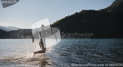 Image of triathlon athlete starting swimming training on lake