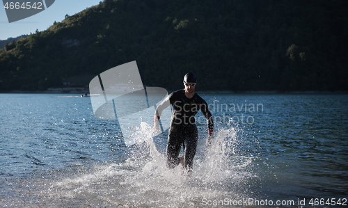 Image of triathlon athlete starting swimming training on lake