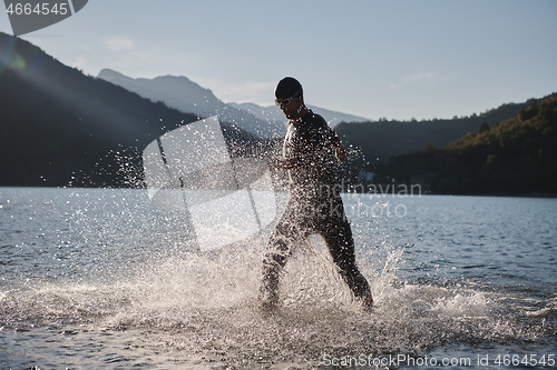 Image of triathlon athlete starting swimming training on lake