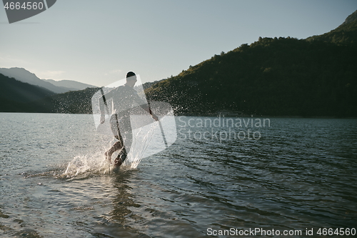 Image of triathlon athlete starting swimming training on lake