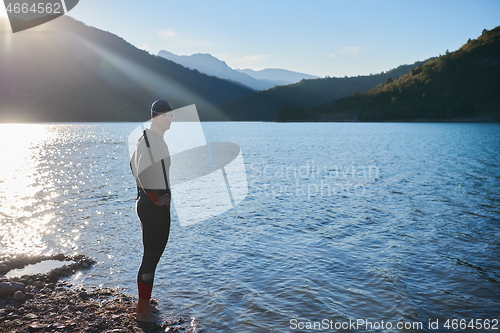 Image of triathlon athlete starting swimming training on lake