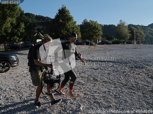 Image of videographer taking action shot of triathlon swimming athlete