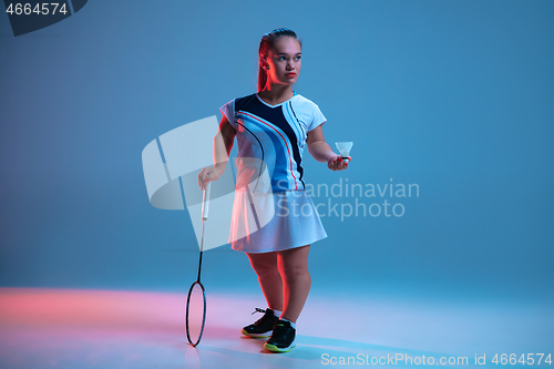 Image of Beautiful dwarf woman practicing in badminton isolated on blue background in neon light