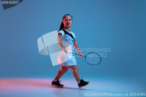 Image of Beautiful dwarf woman practicing in badminton isolated on blue background in neon light