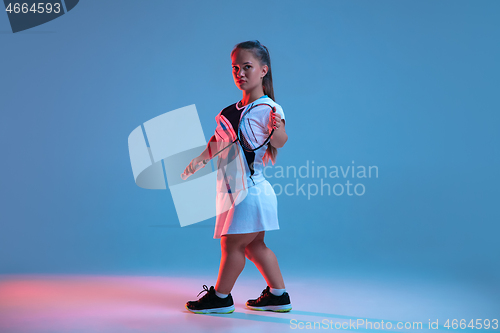 Image of Beautiful dwarf woman practicing in badminton isolated on blue background in neon light