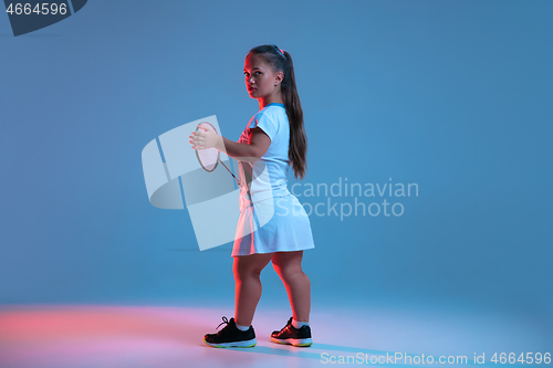 Image of Beautiful dwarf woman practicing in badminton isolated on blue background in neon light