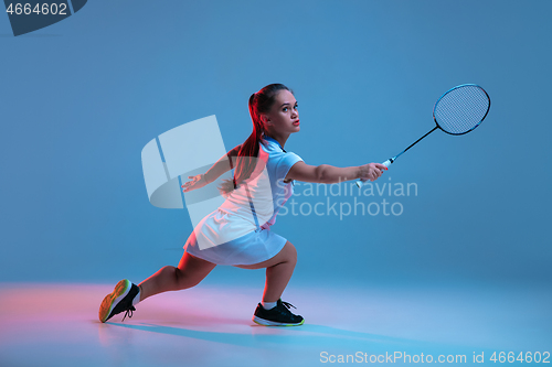 Image of Beautiful dwarf woman practicing in badminton isolated on blue background in neon light