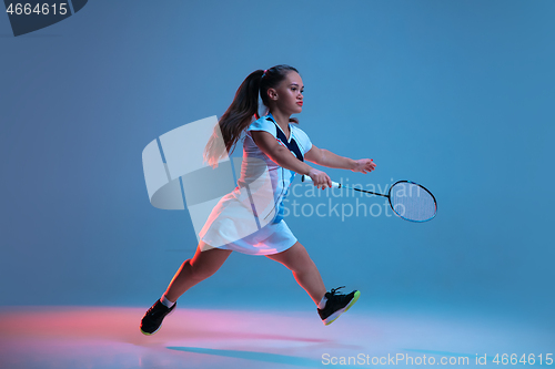 Image of Beautiful dwarf woman practicing in badminton isolated on blue background in neon light