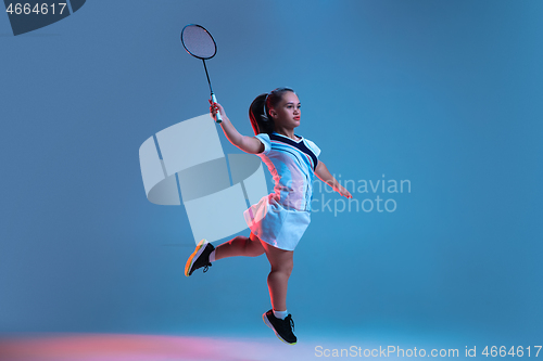 Image of Beautiful dwarf woman practicing in badminton isolated on blue background in neon light