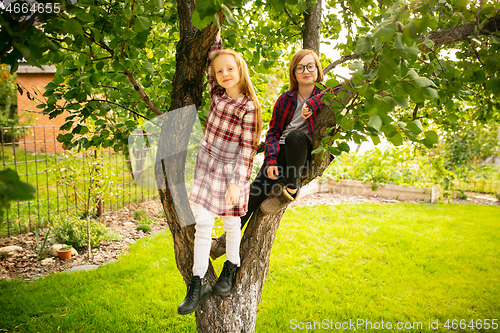 Image of Happy brother and sister playing in a garden outdoors together