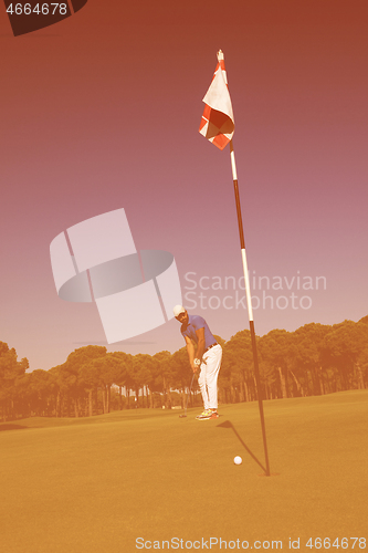 Image of golf player hitting shot at sunny day