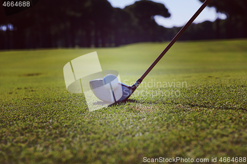 Image of golf player placing ball on tee