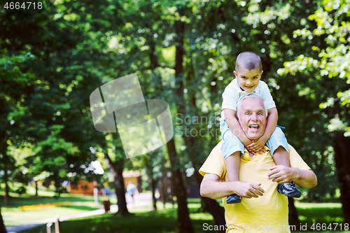 Image of grandfather and child have fun  in park