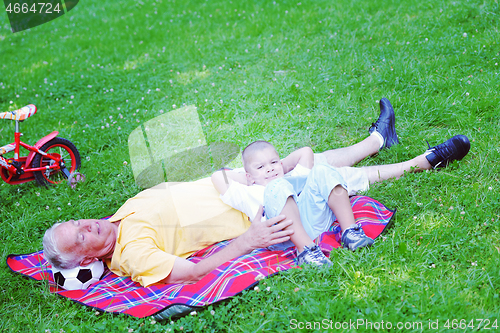 Image of grandfather and child in park using tablet