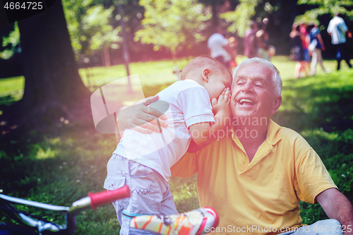 Image of grandfather and child have fun  in park