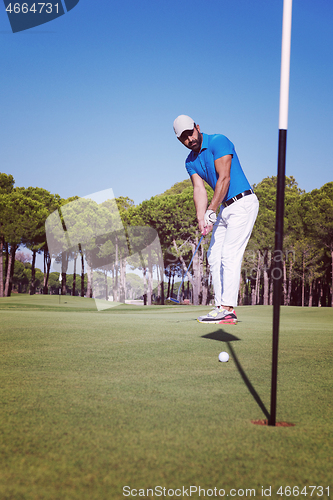 Image of golf player hitting shot at sunny day