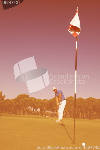 Image of golf player hitting shot at sunny day