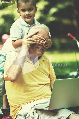 Image of grandfather and child using laptop