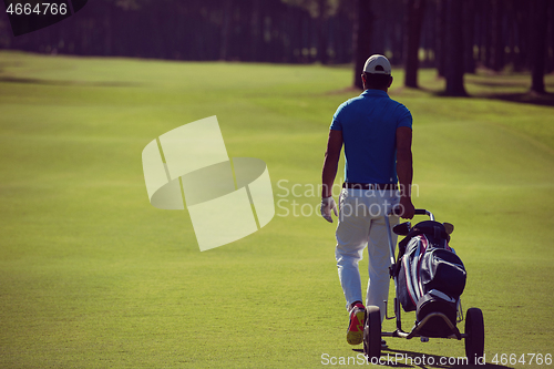 Image of golf player walking with wheel bag