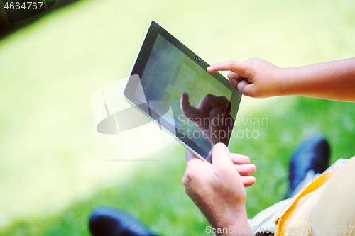 Image of grandfather and child in park using tablet