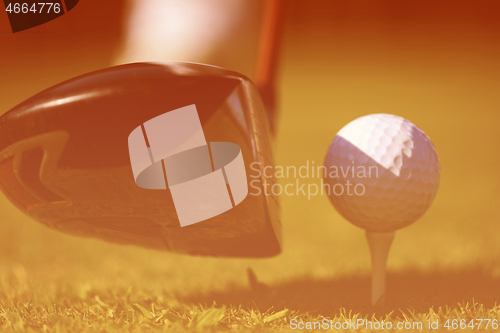 Image of golf club and ball in grass