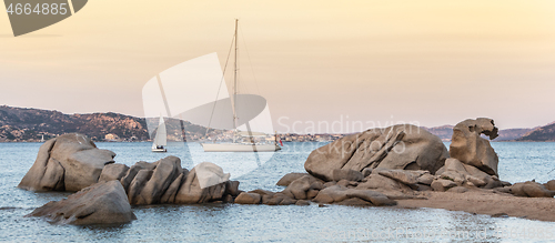 Image of Sailboat sailing by beautiful rocky formations on the Spiaggia di Punta Nera beach. Luxury summer adventure, active vacation in Mediterranean sea, Costa Smeralda, Sardinia, Italy