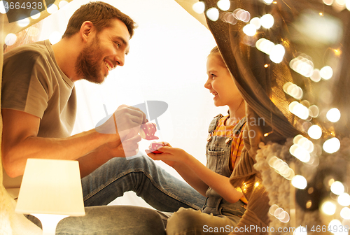 Image of family playing tea party in kids tent at home