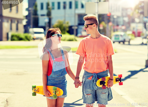 Image of teenage couple with skateboards on city street