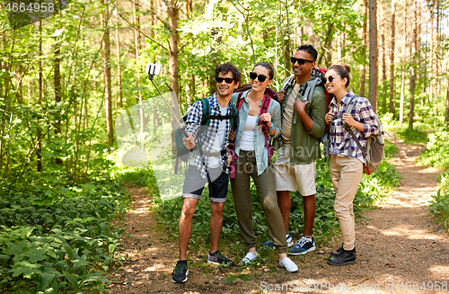 Image of friends with backpacks hiking and taking selfie