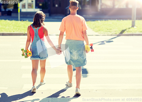 Image of teenage couple with skateboards on city crosswalk